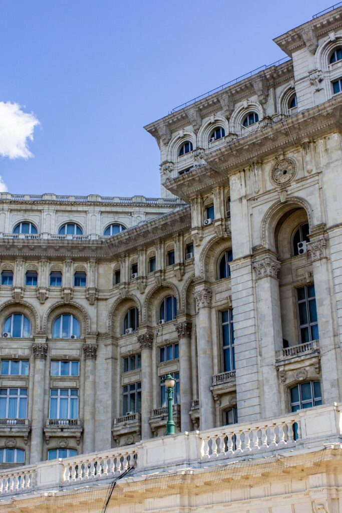 Ornate facade of Palace of the Parliament in Bucharest under clear blue sky.