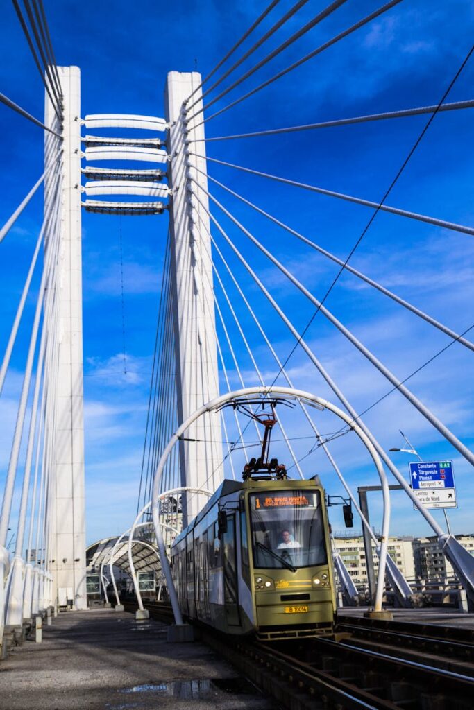 A modern urban bridge featuring an electric train in Bucharest during a clear day.